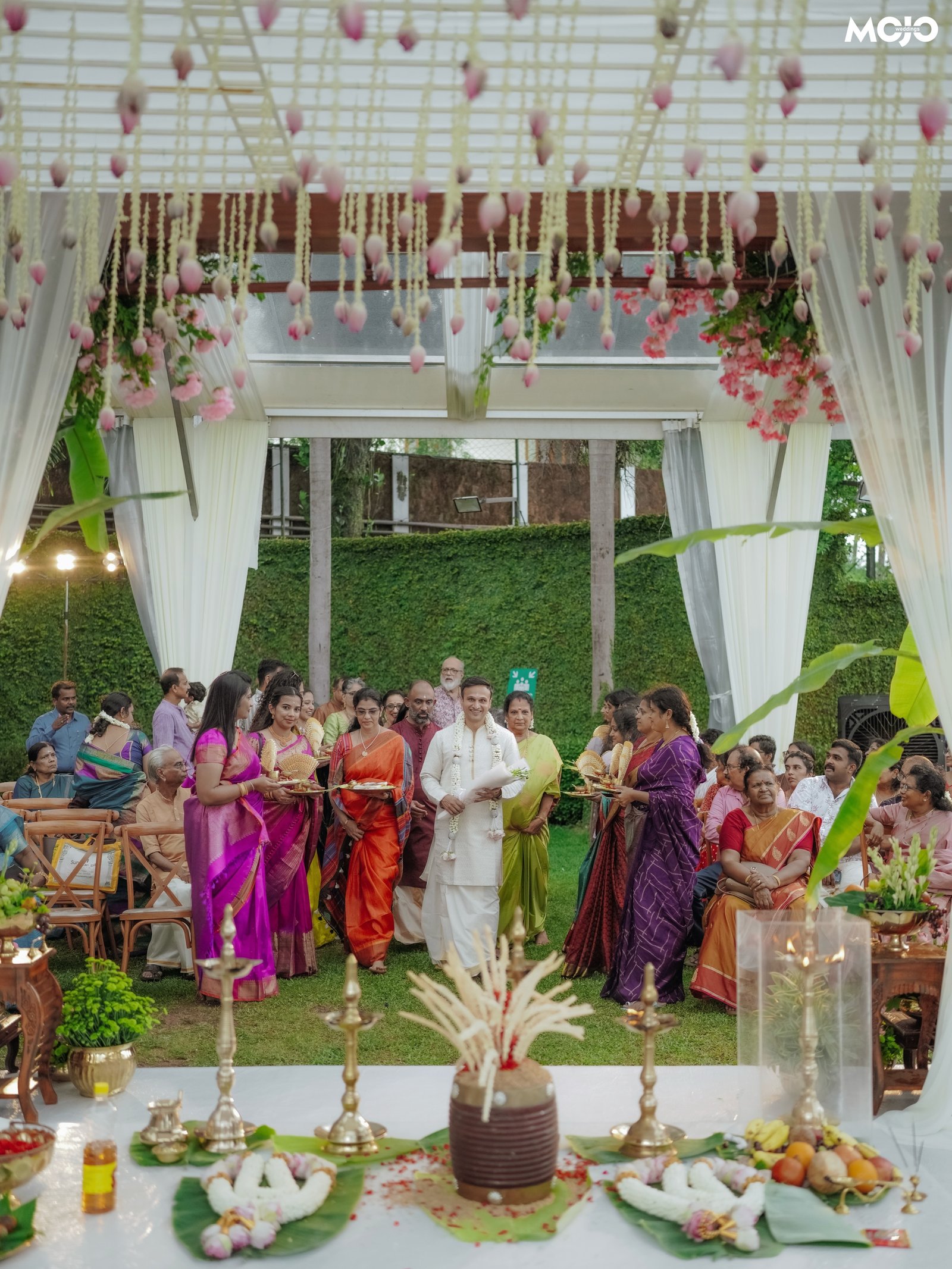 A groom entering a flower-filled wedding ceremony